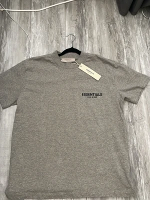Essentials fear of god tshirt - Säljer en helt ny Essentials t-shirt i färgen Grey Heather. Aldrig använd och alla originaltags sitter kvar. Stilren logga på bröstet och den klassiska gummiloggan i nacken. Väldigt hög kvalitet på tyget (heavyweight cotton). XS/S 