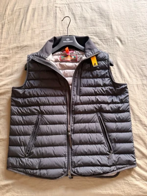 Grå dunväst från Parajumpers - Äkta Parajumpers väst som beställdes från länna sprorts. Den är i storlek L men passar mycket bättre som M. Skriv gärna om det finns frågor