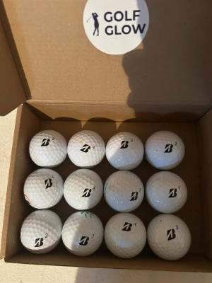 Bridegestonemix 12-pack  - Säljer en box med tolv vita golfbollar från Bridgestone. Bollarna har klassisk dimple-design och är märkta med siffror och Bridgestones logga. Perfekt för dig som vill fylla på golfbagen inför nästa runda.