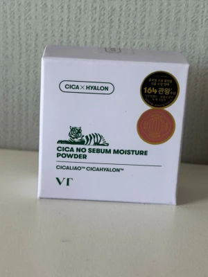 VT Cica No Sebum Moisture Powder - Cica No Sebum Moisture Powder från VT är ett genomskinligt puder som hjälper till att kontrollera olja och ge en matt finish. Innehåller Cicaliao och Cicahyalon för att lugna huden. 