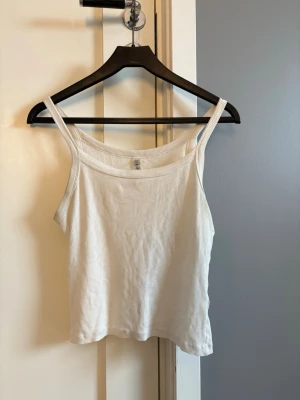 Vit ribbad linnetopp från Lindex  - Säljer en enkel och fräsch vit ribbad linnetopp från Lindex med  smala axelband .
