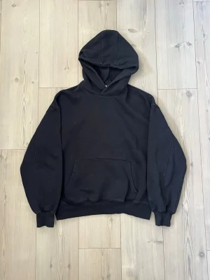 Svart oversized hoodie - En svart oversized hoodie från Junkyard med huva och stor magficka framtill. Hoodien har ribbade muddar vid ärmslut och nederkant, samt en klassisk avslappnad passform. Perfekt för en chill och stilren look. Materialet känns mjukt och bekvämt, troligtvis bomullsblandning.