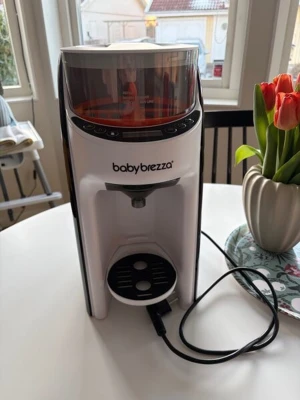 Baby Brezza pulverblandare vit - Automatisk pulverblandare från Baby Brezza i vit plast med svarta detaljer och transparent lock. Perfekt för att snabbt blanda välling eller mjölkersättning. Enkel att använda med digitala knappar på framsidan.