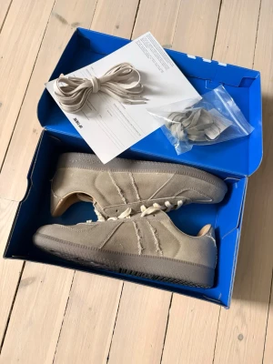 Adidas BW Army sneakers Silver Pebble - Adidas BW Army sneakers Silver Pebble i beige med ljusa snören och grå sula. Skorna har en cool kombination av canvas och mocka, med fransade detaljer längs sidorna och rund tå. Innersulan är ljus och mjuk för extra komfort. Levereras med extra skosnören och originalkartong. Helt nya och en nästan slutsåld modell!