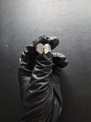 Silverfärgad ring - Unik accessoar i silverfärgad metall med två stiliserade ansikten som möts framtill. Designen är öppen och konstnärlig, perfekt för dig som gillar kreativa och personliga detaljer i din stil. Väldigt fin grej att köpa till din partner. Har man fler frågor kan man fråga.