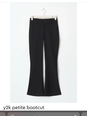 Svarta petite bootcut byxor Y2K-stil - Helt nya snygga svarta bootcut byxor i Y2K-stil med två knappar framtill i storlek S. Byxorna har låtsasfickor baktill som ger en snygg detalj. De är helt nya med prislapp på, nypris 500kr, säljer för 400kr men är öppen för bud. Slutsålda online och i butik. Från gina tricot❣️