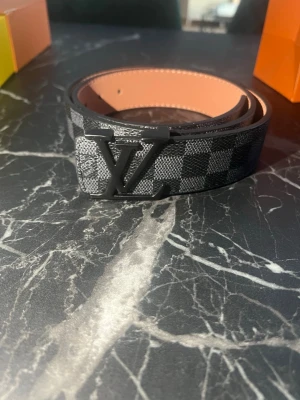 Rutig bälte med logga - Säljer min oanvända bälte. Har andra färger ochså. Hör av er!