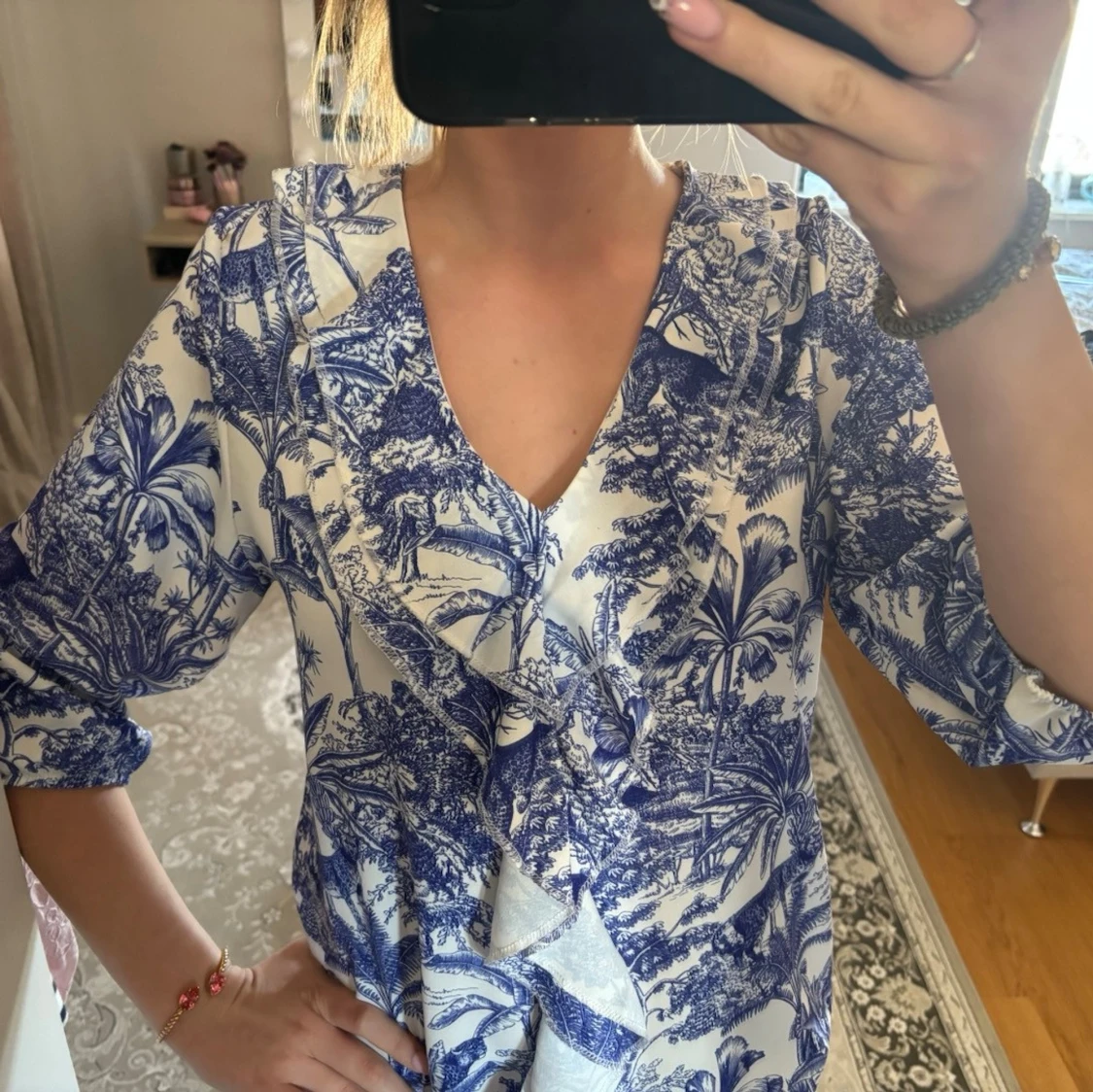 Blåvit blus med volang och v-ringning