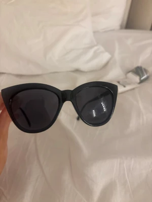 Svarta cat eye solglasögon  - Snygga svarta cat eye solglasögon från Lindex med bred båge och mörka glas. Perfekta för dig som vill ha en trendig och stilren look. Tillverkade i syntetmaterial och passar till alla outfits.