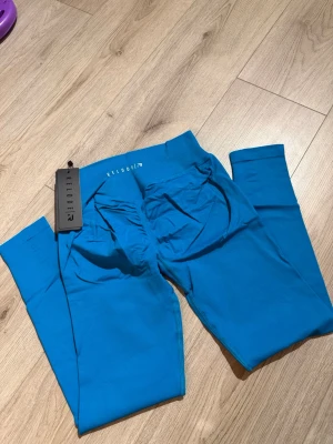 Tränings tights Relode stl m regular  - Snygga blå leggings från Relode med tight passform. Tillverkade i ett stretchigt material som sitter skönt och framhäver formerna. Perfekta för träning eller chill. Diskret logga baktill. Kommer med originalpåse och tag kvar. Storlek m regular 