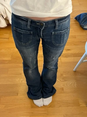 Mörkblå bootcut jeans - Edgy lågmidjade bootcut med slitage detalj. Så jävla coola, älskar