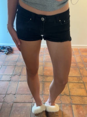 Svarta lågmidjade jeansshorts  - Säljer ett par svarta jeansshorts från Forever 21. Shortsen har låg midja och en snygg, tight passform som passar perfekt till sommaren. Storlek 38