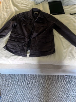 Svart jacka från Alvaro Moreno - Stilren svart jacka från Alvaro Moreno med flera praktiska fickor framtill och klassisk krage. Jackan har knappstängning och är perfekt för dig som gillar en enkel men snygg look. Passar till många olika outfits.