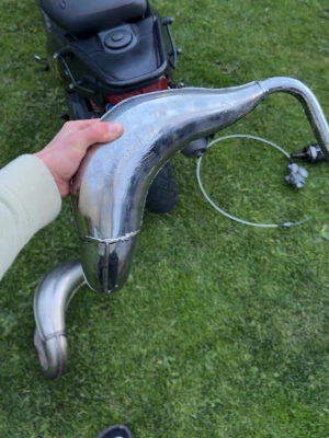 Avgassystem till moped - Säljer ett avgassystem till moped, komplett med böjd kromad expansionskammare och ljuddämpare i kolfiber och metall. Passar till dig som vill uppgradera ljudet och prestandan på din moppe. Snygg design och robust material.