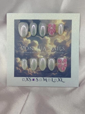 Mist (S);Short Almond - Snygga handgjorda press-on naglar i kort mandelform. Naglarna är vita med skimrande glitter och har två accentnaglar med rosa 3D-blommor. Perfekt för dig som vill ha en unik och kreativ look. Handgjorda och detaljerade för extra wow-effekt.S: 15 mm, 11,5 mm, 12 mm, 11 mm, 9 mm 