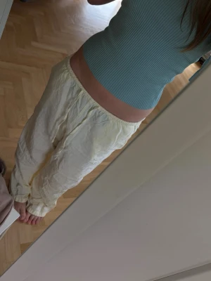 Ljusgrön/turquoise ribbad topp med kort ärm - Supersöt ljusgrön/turquoise ribbad topp med korta ärmar och figurnära passform. Toppen har en croppad längd och är tillverkad i ett mjukt, stretchigt material som sitter bekvämt. Perfekt att styla med både jeans och kjol.
