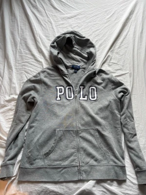 Grå hoodie från Polo Ralph Lauren - Snygg grå hoodie från Polo Ralph Lauren storlek 18- 20 men sitter som s 