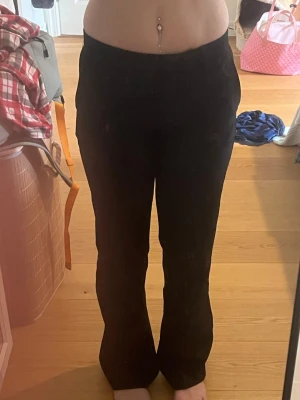 Svarta kostymbyxor med rak passform - Säljer ett par svarta kostymbyxor med hög midja och rak passform. Byxorna har en klassisk look och är perfekta till en snygg outfit. Materialet känns mjukt och följsamt, troligtvis polyesterblandning. Inga synliga detaljer eller loggor. Använda mycket men inga tecken på slitage. 