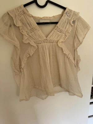 Neo Noir Blus - Supersöt beige blus från Neo Noir med volanger och spetsdetaljer. Perfekt inför sommaren☺️❤️ Passar storlekar XS-S