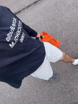 Svart långärmad topp Acne Studios - Svart långärmad topp från Acne Studios med vit text framtill: 'Acne Studios STOCKHOLM 1996'. Avslappnad passform och rund halsringning. Perfekt för en stilren och enkel look. Som ny.