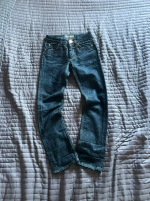 Acne jeans - Säljer ett par klassiska acne jeans i mörkblå tvätt. Modellen har normal passform med smalare ben och fem fickor. Jeansen är tillverkade i slitstark bomull med en snygg, tidlös look och metallknappar. Perfekta till alla typer av outfits.