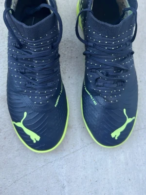 Puma svarta fotbollsskor med neon - Säljer ett par helt nya puma inomhus/futsalskor.Endast testade och i kanonskick! Sjukt sköna och perfekt för inomhusfotboll eller gympa i skolan.Kan skicka via appen eller hämtas. Skriv vid frågor!