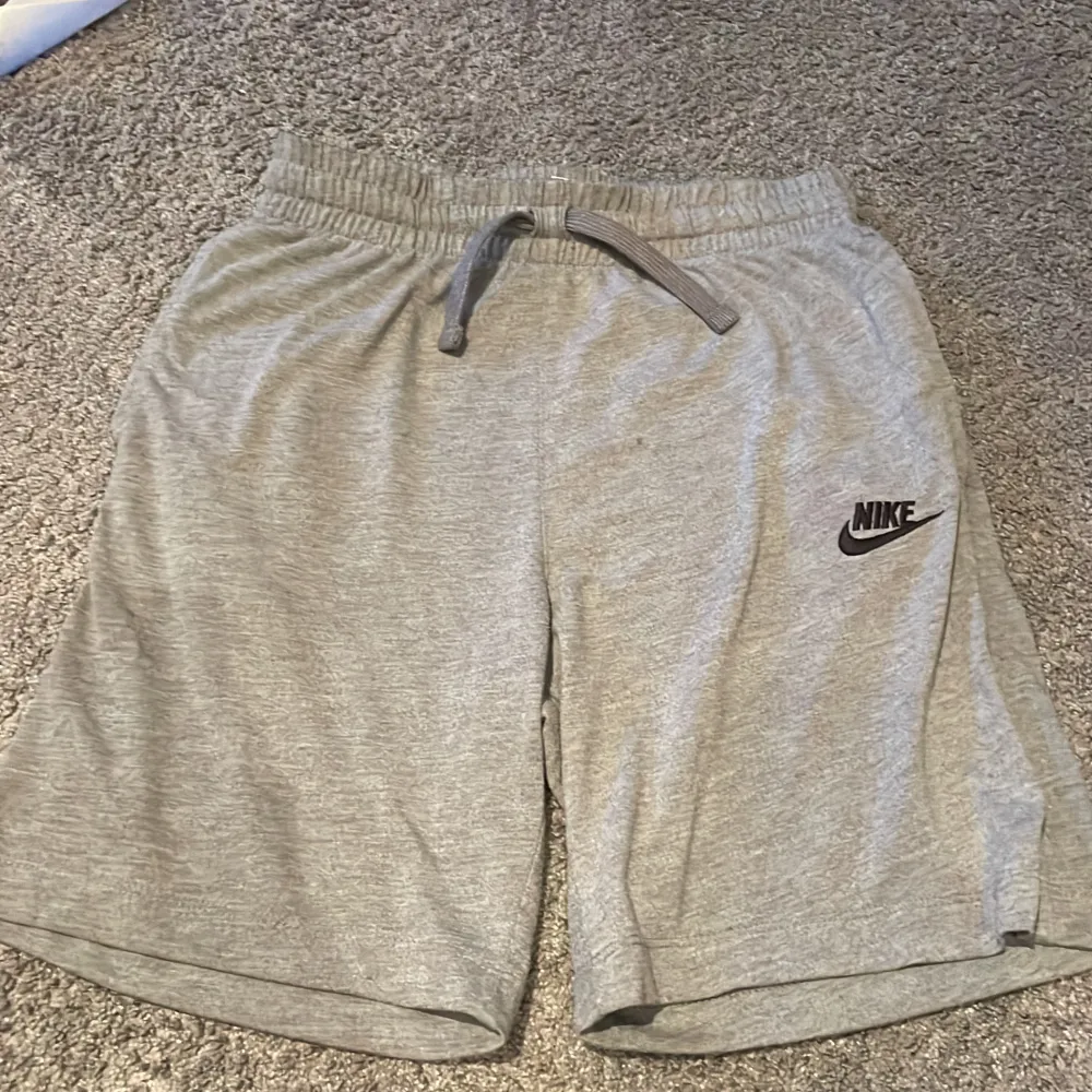 Detta är ett par Nike shorts som är perfekta till sommaren. De är färg grå och är används flertal gånger. På shortsen finns det snören så att du kan spänna in. Tveka inte om att ställa frågor. Shorts.