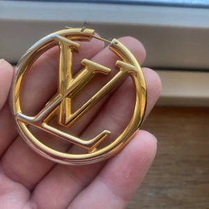 Äkta Louis Vuitton Louise Hoop örhängen  - Guldiga Louis Vuitton Louise hoop örhängen tyvärr nog så har färgen gått bort på vissa ställen därav så låg pris  Nypris 6600:-    Kvitto och dustbag medföljes såklart   Pris kan diskuteras vid snabb affär 