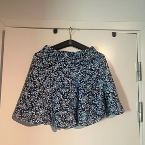 Blå kjol med blommor - söt sommarkjol i storlek small, skulle eventuellt kunna sitta lågmidjat på en xs. En skmmarfavorit som tyvärr blivit för liten. Pris kan diskuteras