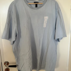 T-Shirt - Ljusblå T-Shirt med avbildning av grekisk skulptur