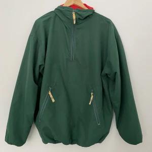 Windbreaker // Daily Sports - En windbreaker från Daily Sports, materialet är väldigt tunt och luftig. Jackan är mörkgrönmed en röd krage. Den är i bra skick förutom två fläckar vid vänster ficka som jag inte lyckats få bort (se bild 4) Kan skickas på post eller mötas upp i Gävle