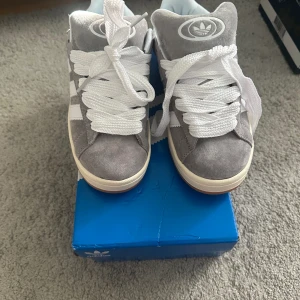 Adidas campus 00s - Helt nya gråa adidas campus som bara är testade. Aldrig använda ute, kartong skickas också med. Finns extra snören oxå. Skriv för fler bilder:)