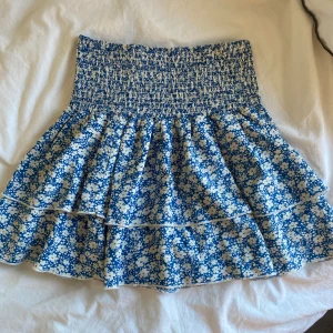 blå volangkjol - blå volangkjol med blommor storlek s men är stretchig så allt från xs-l borde passa bara skriva privat om ni har frågor