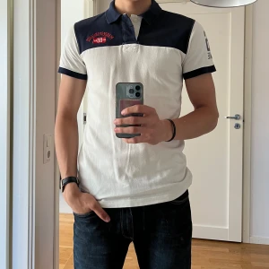 Pikétröja från PeakPerformance - En vit/blå pikétröja från PeakPerformance i storlek M. Inte så använd och i väldigt bra skick. 