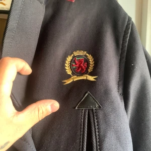 Winter coat - THIS GARMENT FEATURES THE ARCHIVAL TOMMY CREST. THE ICONIC LION, SWORD AND LAURELS MARQUE WAS LAUNCHED IN 1985 TO CELEBRATE THE PREPPY CREDENTIALS OF TOMMY'S FAST COLLECTION  IN THE NINETIES, THE TOMMY CREST BECAME A STREETWEAR FAVORITE