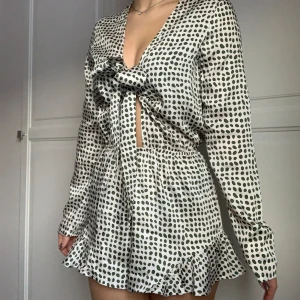 Playsuit / Jumpsuit - Glamorous - Prickig playsuit/jumpsuit med volangdetalj från Glamorous, köpt från Nelly.com. Nyskick - aldrig använd! Vit/cremefärgad med gröna prickar 🌸