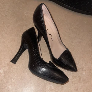 Black heels - Svarta klackskor från Unisa i storlek 37. Klackarna är i krockodilskin och de är mycket bra skick och väldigt bekväma. 