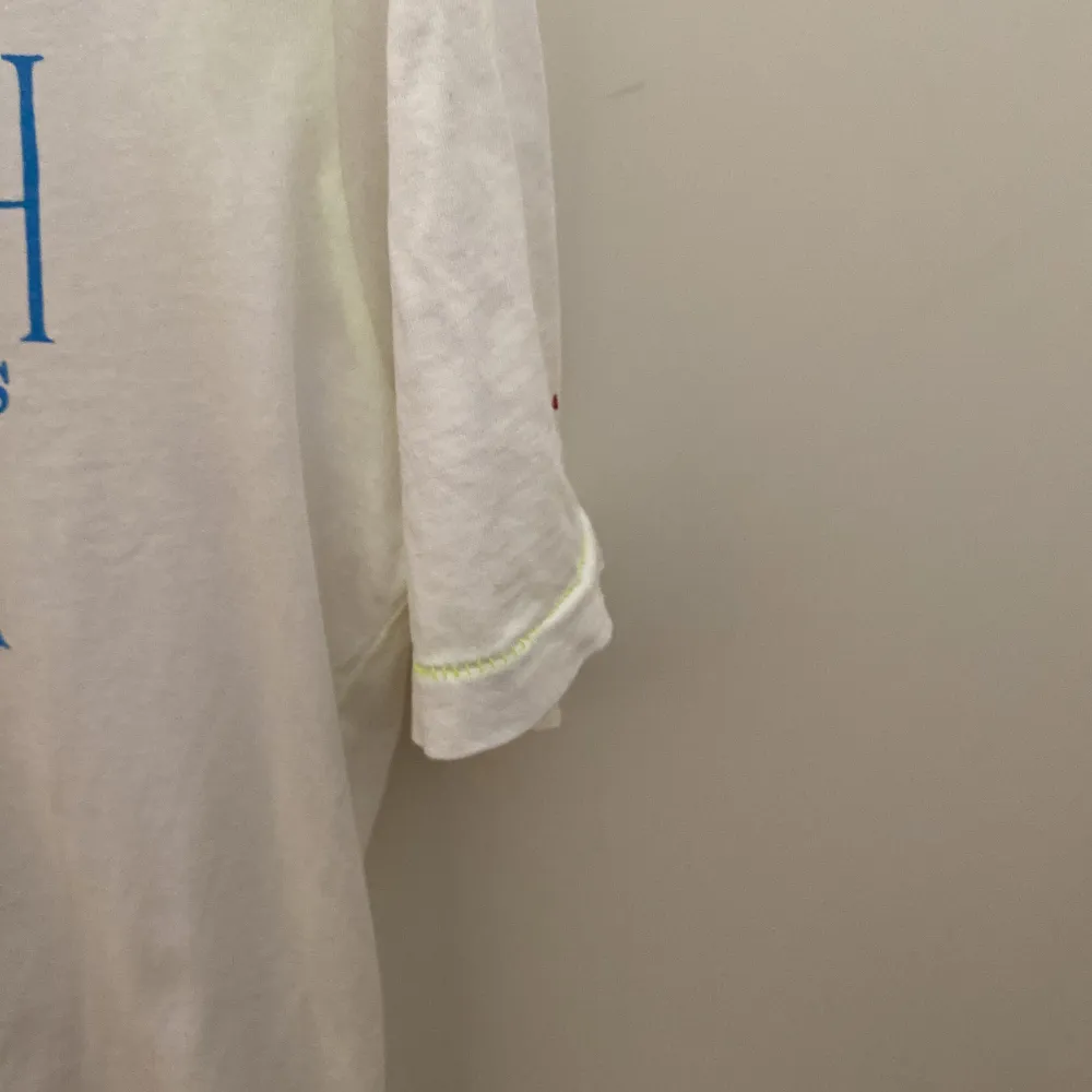 Scotch & Soda T-shirt, vit med blå text, gul rand på armar och nederst. T-shirts.