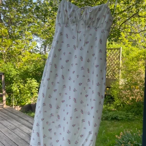 Blommig vit klänning - Size S. Långklänning i siden liknande material, fin och somrig i vit med blomster! 🎂