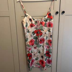 Kort blommig färgglad klänning från nakd, oanvänd stl 36