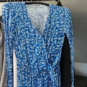Blå sommar klänning - Jag säljer min blommiga sommar klänning eftersom jag inte använder den. Jag har haft den en gång på en skolavslutning sen dess har jag inte använt den. Den är i bra skick. Strl xs. För fler bilder kontakta mig🫶