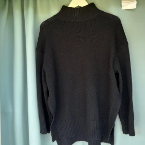 Stickad tröja H&M - Fin stickad tröja från H&M. Den är flitigt använd men fortfarande fint skick. Den har fina detaljer där den har slits på sidan av tröjan och även uppe bak i nacken. 