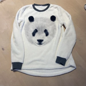 Gosig tröja - Jätte skön tjock långärmad tröja. Den har en panda på och två små pom poms som öron. Jätte mysig och gosig, inga fläckar