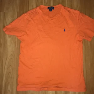Orange polo ralph lauren t- shirt  - Jätte bra skick T-shirt. storlek L, knappt använd. Lite knottrig men det ser man bara på jätte nära håll.