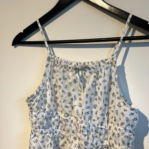 Blommig klänning - Säljer en fin somrig klänning med så blommor på. Använd ett fåtal gånger för jag tycker inte att jag passar i de . Har också växt ut den så tänker att det blir bättre att sälja den. Inga fläckar eller hål. Gott skick!☀️🪻