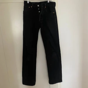 Svarta Levis jeans  - Super snygga 501 jeans från Levis. Är ett litet hål på framsidan men tror att det ska vara så (skriver för säkerhets skull, inget jag tycker ser fult/konstigt ut) 🙌🥰