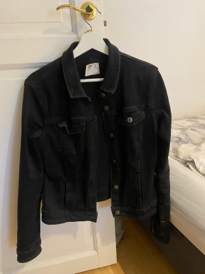 Svart jeansjacka  - En svart jeansjacka från Bershka, helt okej skick men den har nått år på nacken. Säljes då den är lite liten för mig och ej används längre! Pris går att diskutera :)
