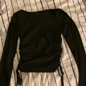 Säljer denna långärmade svarta basic tröjan med snören på sidorna. Jätte gullig men använder tyvärr inte längre. Strl är M. ❤️