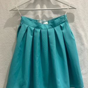 Turkos kjol - Turkos kjol, dragkedja i sidan.   Strl: S men mer en 32a väldigt liten, se bild. 