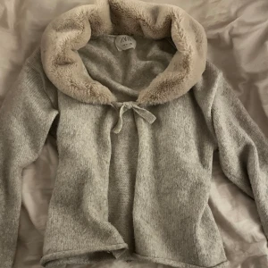 Stickad grå tröja - Supersöt stickad grå tröja med en avtagbar pälskrage som är beige. 💞 Man kan knyta upp koftan om man vill och gå utan pälsen, fortfarande supersöt grå stickad kofta som man kan se på andra bilden. Pälsen är fortfarande jättemjuk, har knappt använt☺️